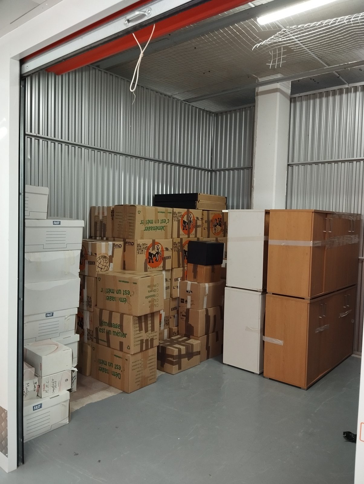 Box de garde-meuble 20 m² DTS rempli de cartons, électroménager et mobilier protégé